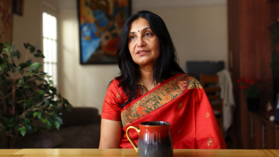 hina sat on chair in her home wearing sari