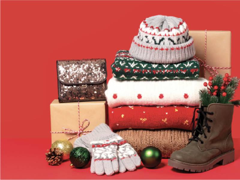 A pile Christmas-themed jumpers, accessories and gifts