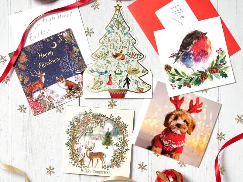 Christmas cards and ribbons scattered on a table