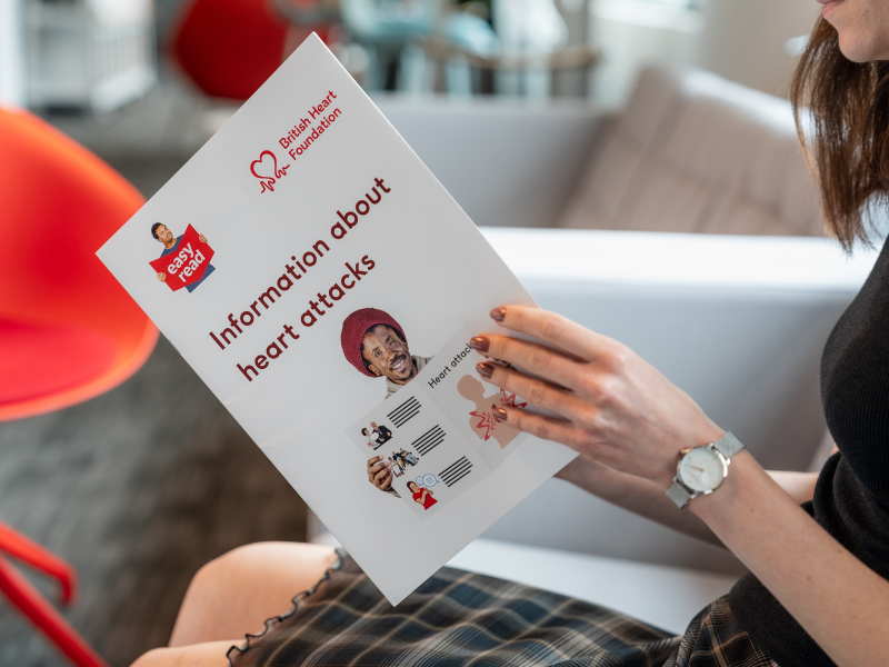 Person reading a British Heart Foundation Easy Read booklet titled 'Information about heart attacks.'
