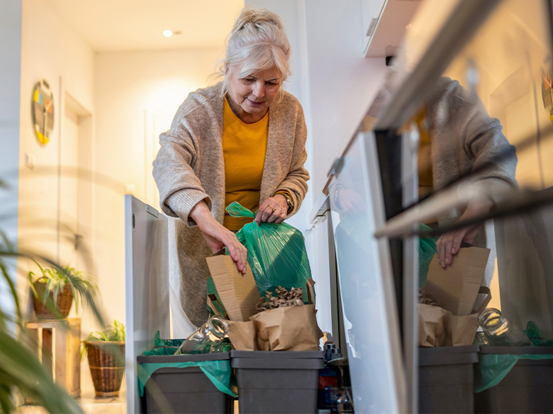 mature woman emptying recycling bin
