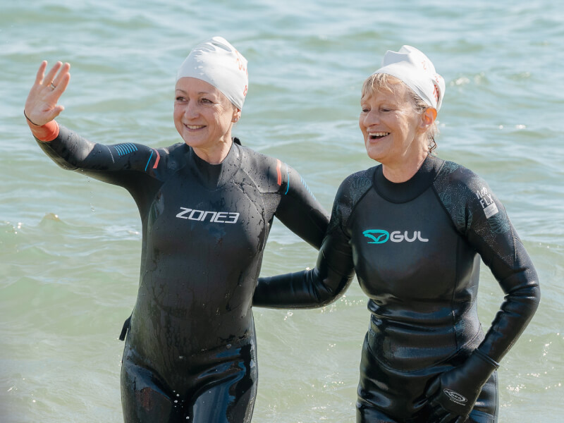 Two women taking part in a swimming event to raise money.
