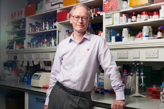 Professor Hugh Watkins standing in a lab