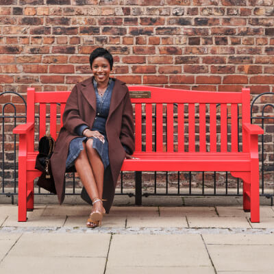 Michelle, sitting on a bench outdoors.