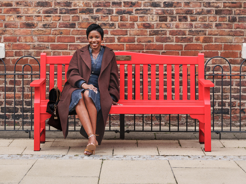 Michelle, sitting on a red bench outdoors.