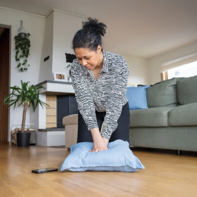 Person practising CPR on a cushion