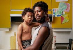 A father holding his son, who has a midline chest scar from heart surgery.