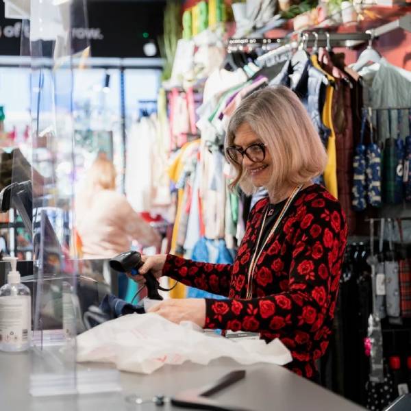 A volunteer serves customers at a BHF shop