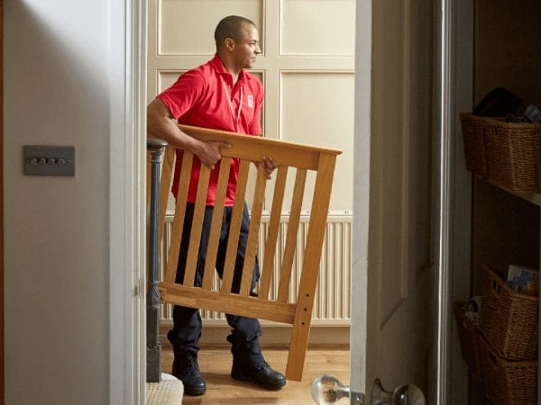 A BHF employee removes part of a bed frame from someone's home.