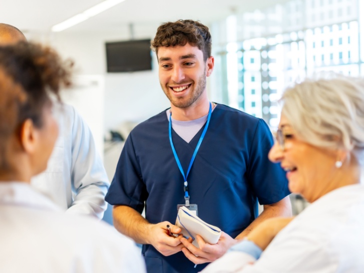 Healthcare professionals talking and smiling at work.