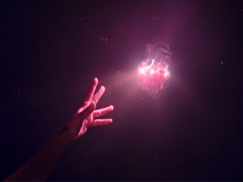 A hand reaching out to grab a holographic heart.