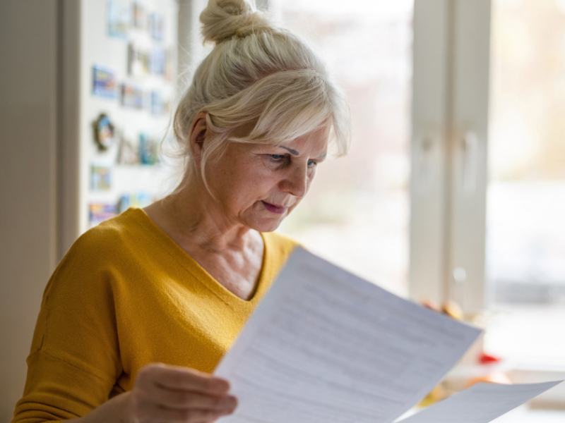 An executor of a Will is reading a contract in her home.