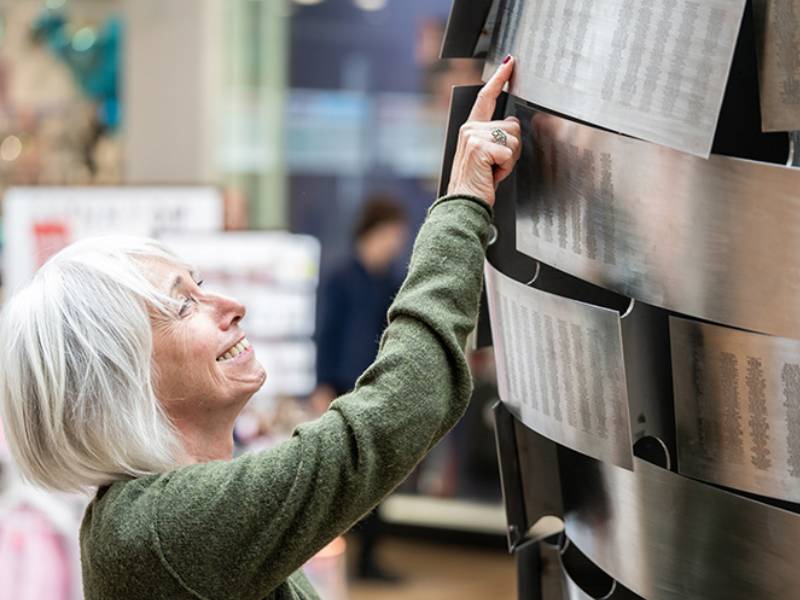 Woman finding her engraving on the Heart of Steel sculpture.