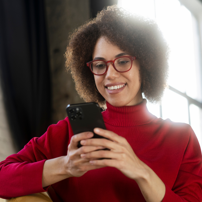 A smiling woman making a donation by phone.
