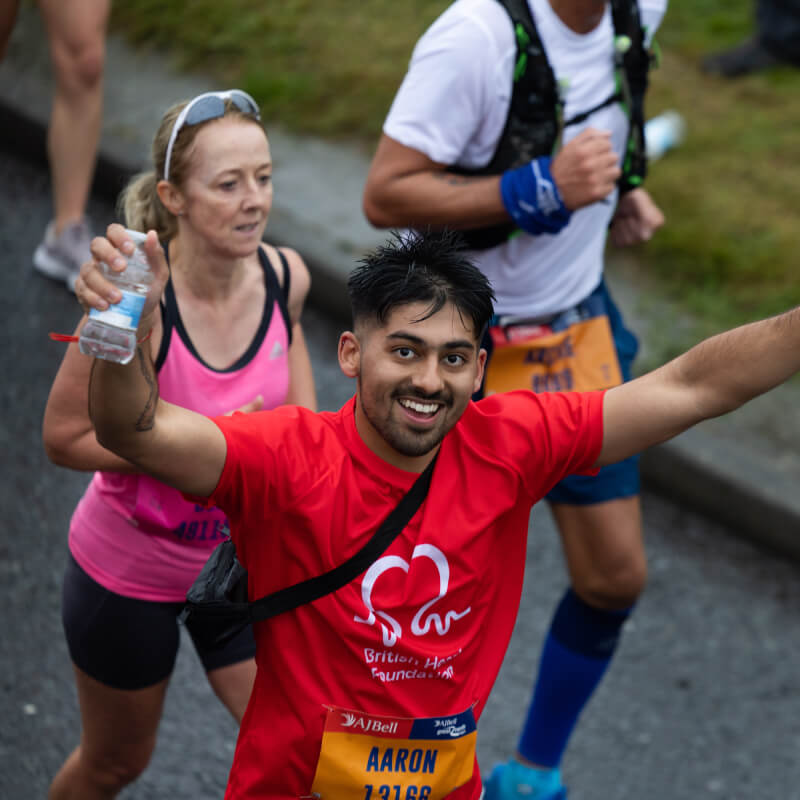 A runner smiling holding their arms out