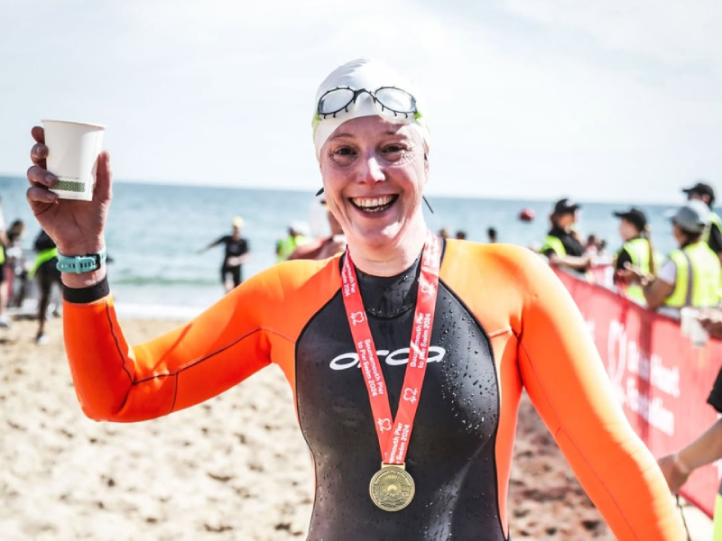 Dr Cathy Wilson, celebrating her swim on the beach.