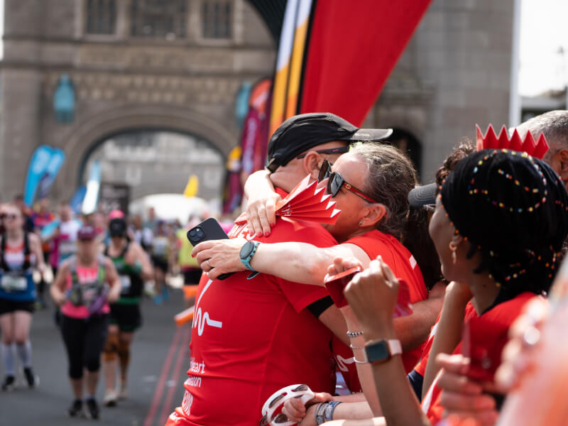 BHF runner hugging a spectator in the crowd