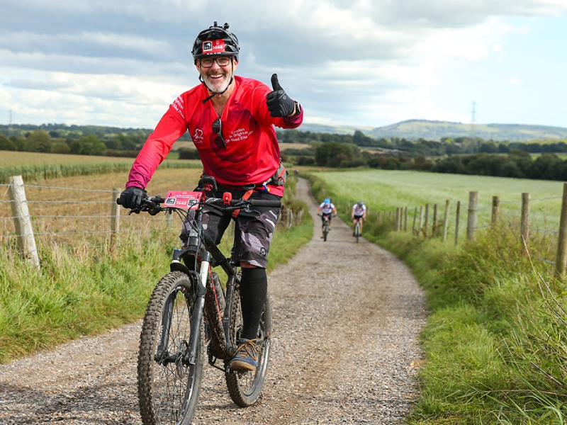 A man with his thumb up while riding the London to Brighton Off Road Bike Ride