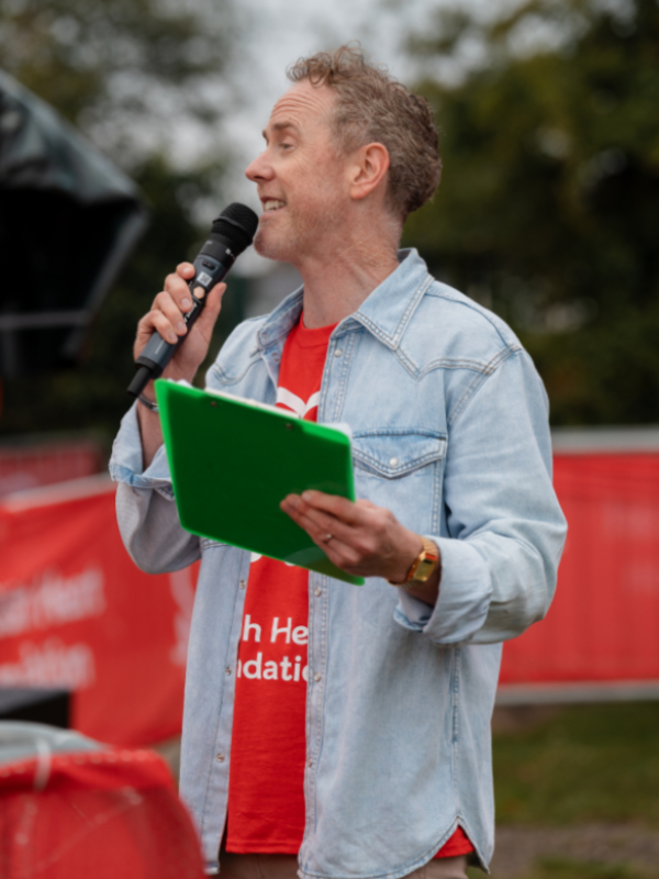 A presenter talking into a microphone at the starting line of the London to Brighton Off Road Bike Ride