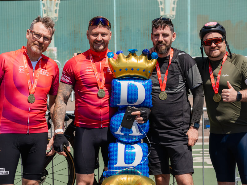 A group of bike riders smiling with medals