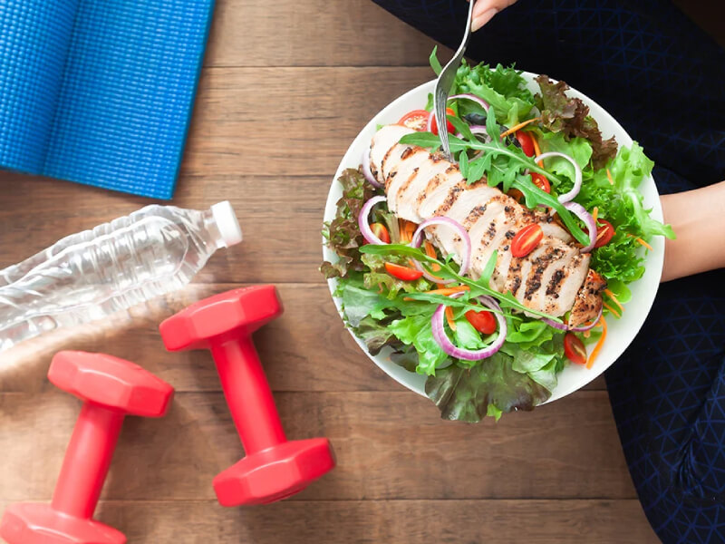 A bowl of salad and some exercise equipment