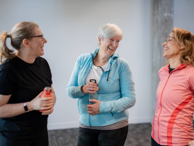 three people wearing fitness gear and talking