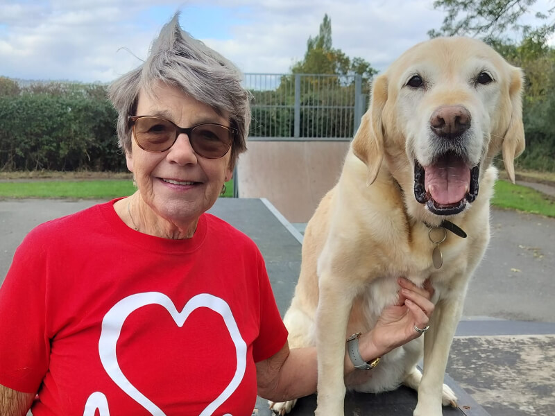 A photograph of Sue, walking with her dog.