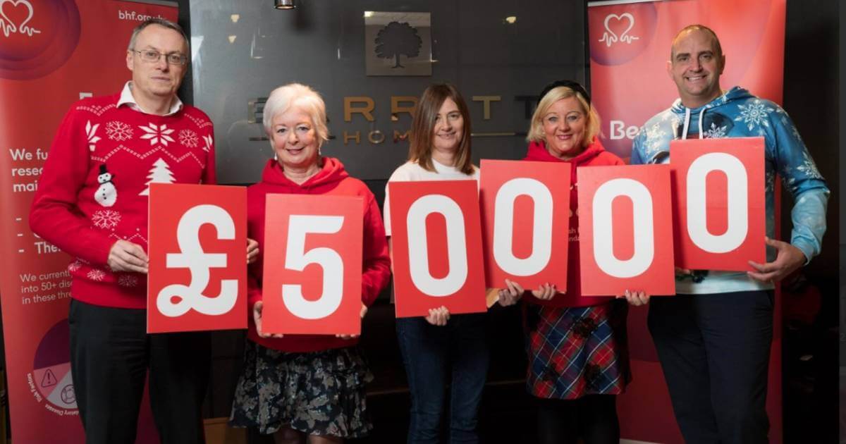 People holding up cards that together, show a total of £50000