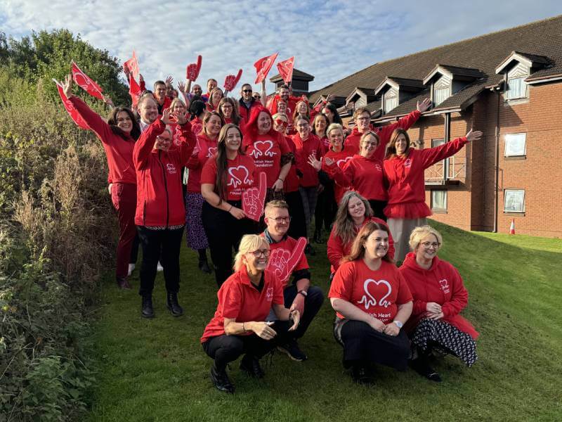 A large group of Fundraising Managers wearing red BHF t-shirts are posing for a group photo.