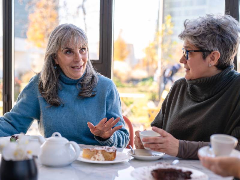 Two women chatting over coffee and cake