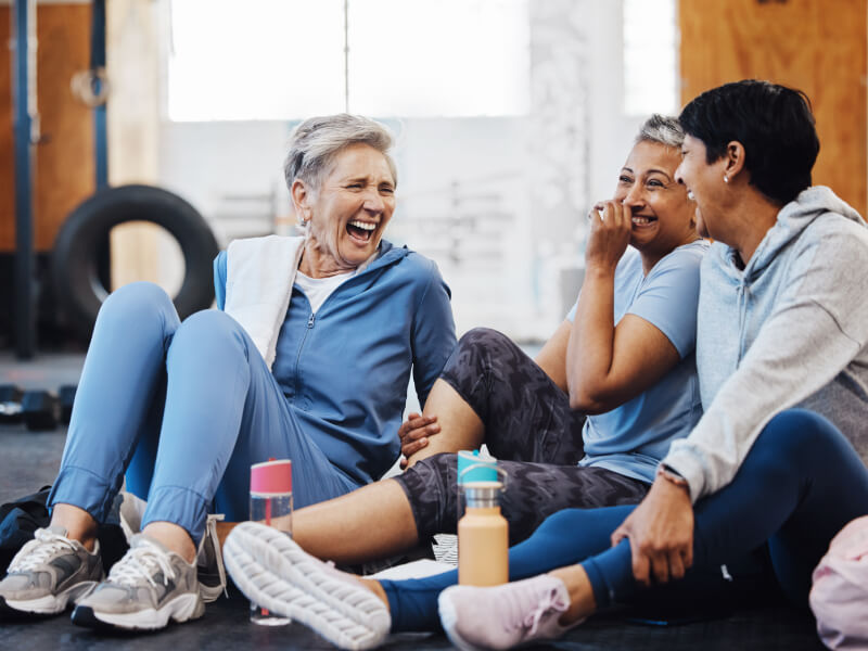 3 women chatting in a gym after a workout.