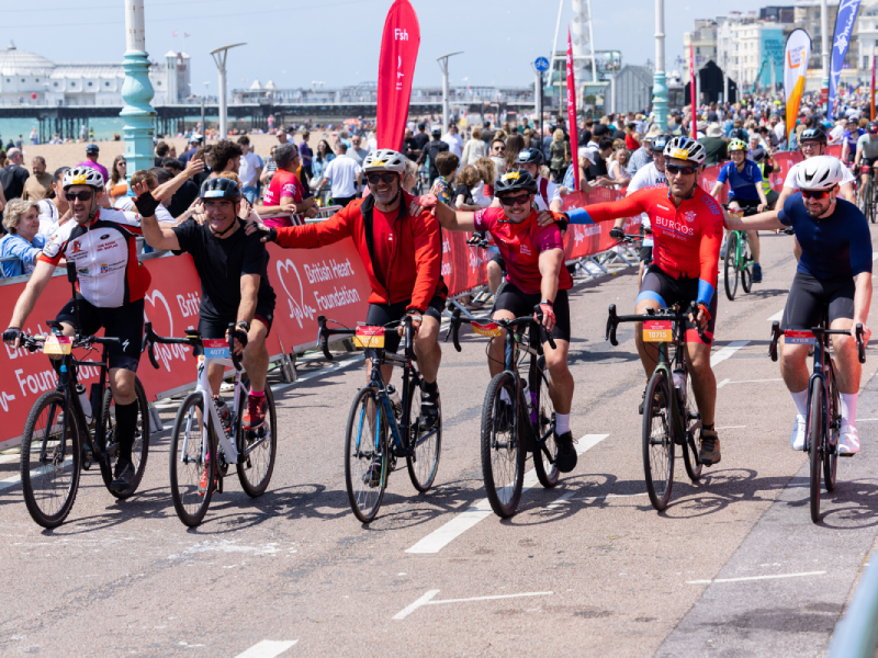 A group of bike riders approaching the finish line at the London to Brighton ride