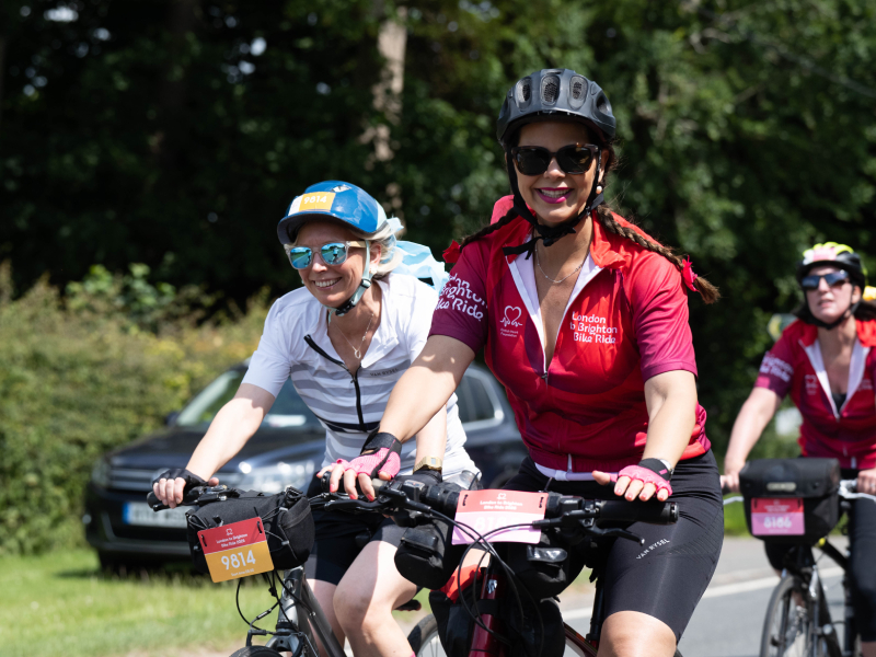 Riders smiling and taking part in the London to Brighton bike ride