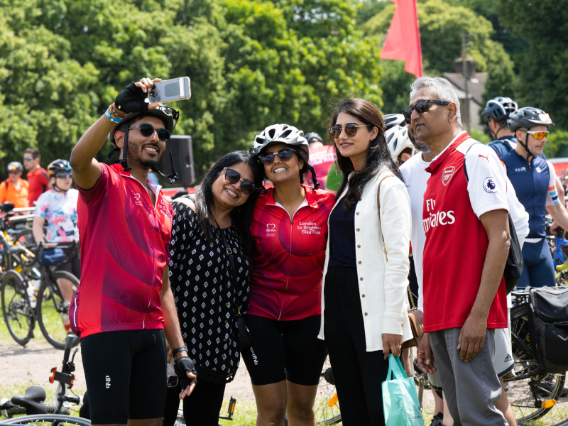 A group of bike riders posing for a picture and smiling