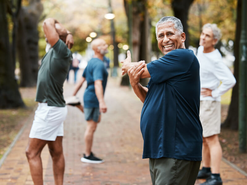 A group of men stretch in a park 