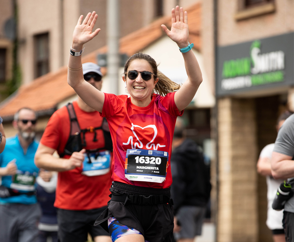 Person running in a race with arms in the air
