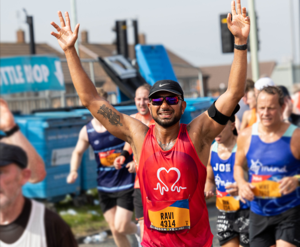 Person running in a race with arms in the air
