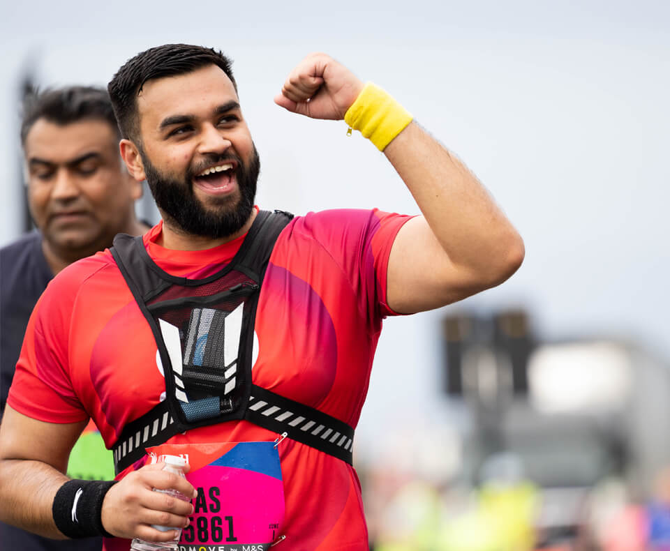 Person running in a race with arm in the air