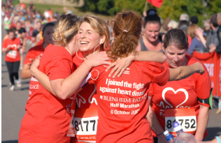 A group of smiling ladies hug at the Blenheim Half Marathon.
