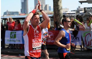 BHF London Marathon runner clapping whilst running.