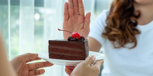 woman saying no to a chocolate cake