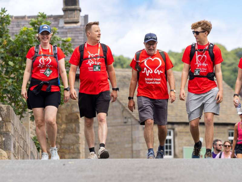 A group of people take part in a BHF walk wearing BHF-branded t-shirts.