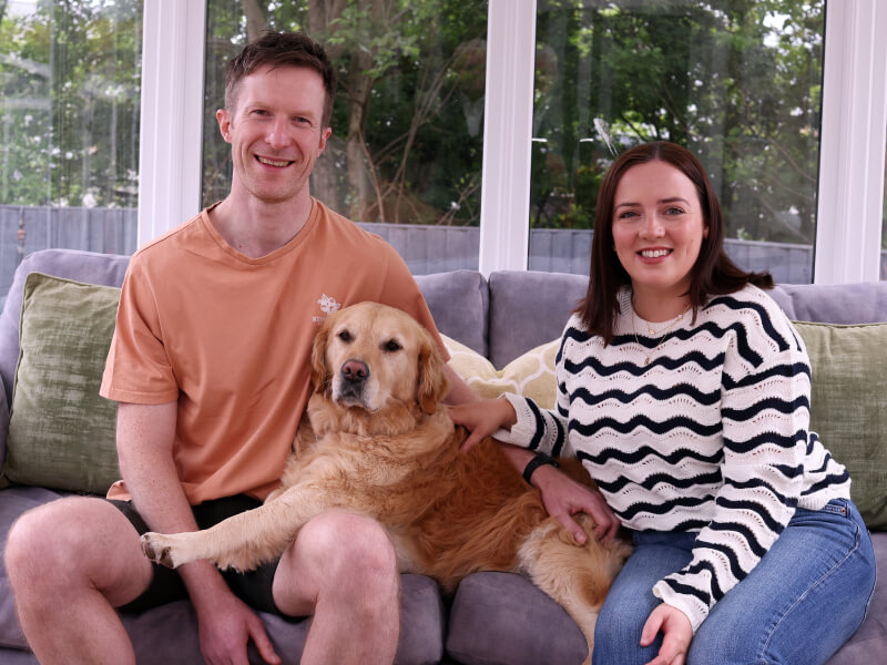Hannah, Polly and Adam sat on a sofa in a conservatory