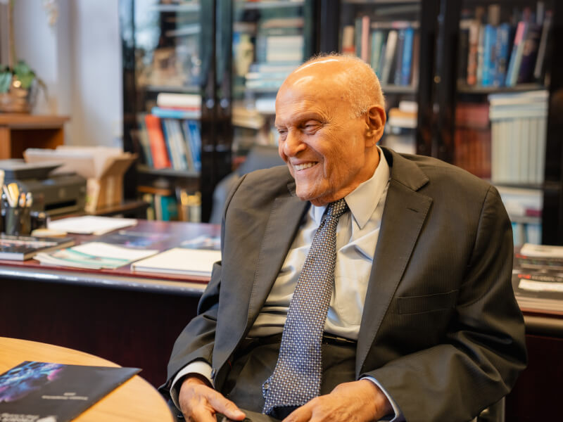 Professor Magdi Yacoub sat in an office with a bookcase filled with books behind him