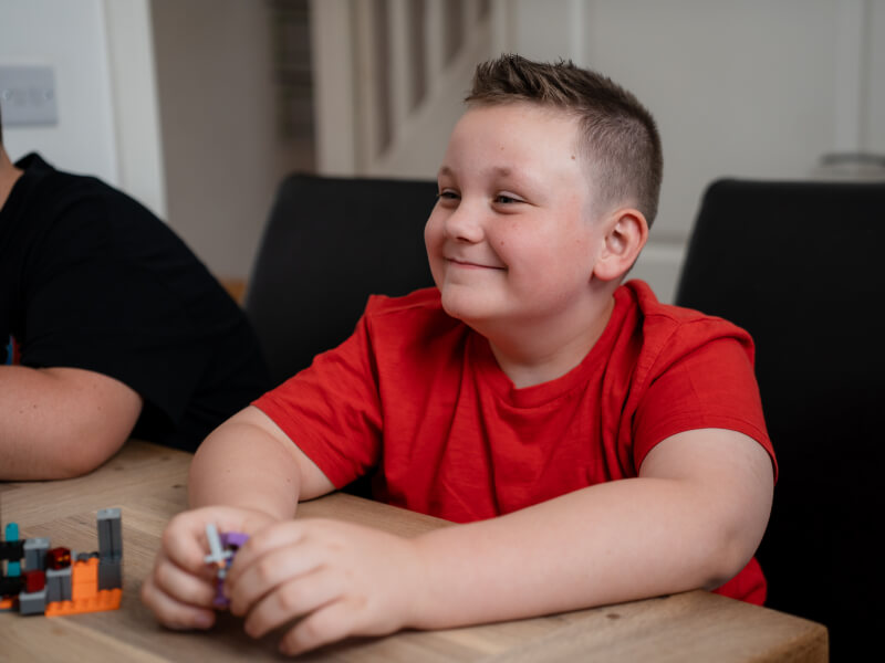 James sits at a table with lego in his hands