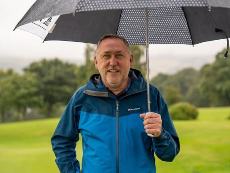 A man outside holding an umbrella