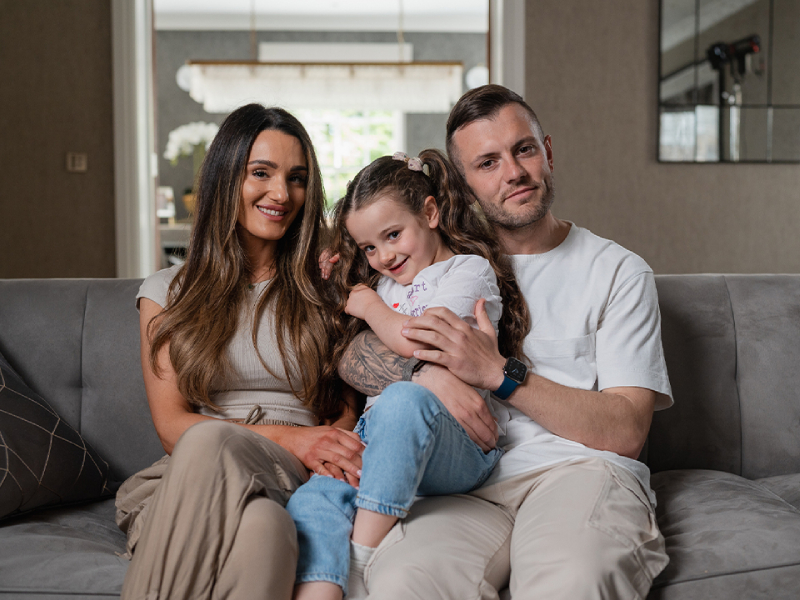 A family smiling with their child Sienna