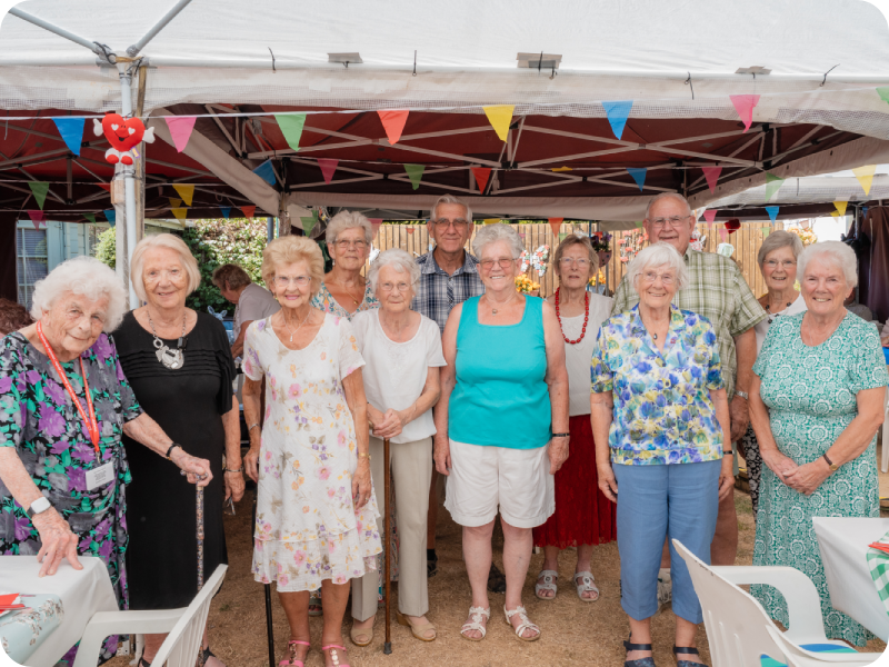 Carterton Branch members standing together under a decorated marquee at a community event.