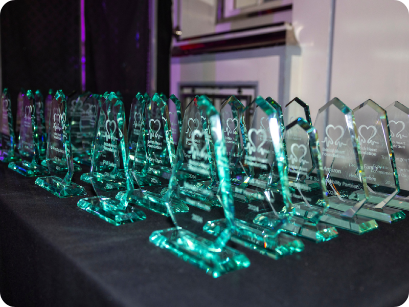 Rows of glass awards on a black table at the Heart Hero Awards.