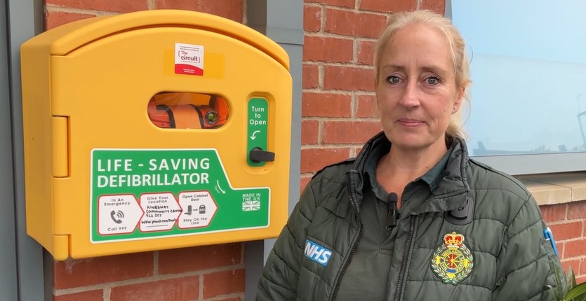 A female paramedic from Southwestern Ambulance Service standing next to a defibrillator